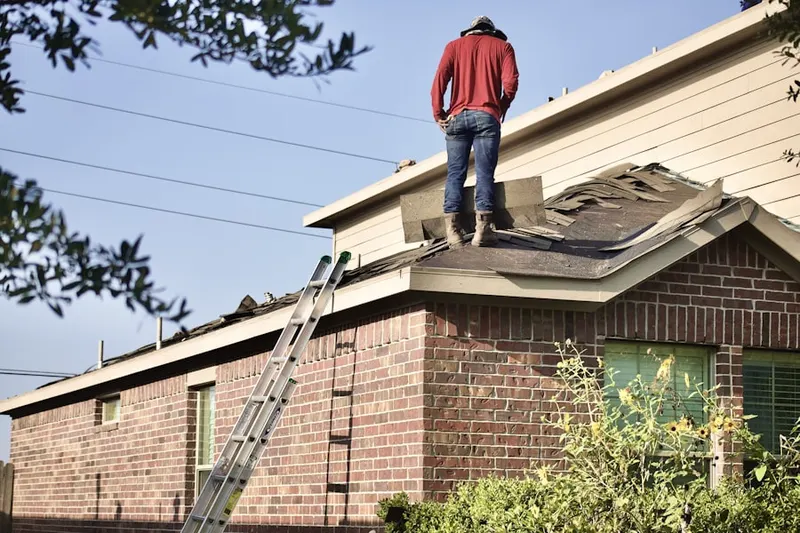 Professional roofer working on a residential roof in Hewlett Bay Park